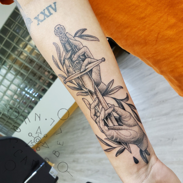 Fine line black and grey dotwork dagger through palm forewarm tattoo. Book a custom tattoo with John at Sacred Mandala Studio - Durham, NC.